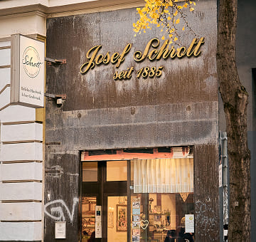 Eingangsbereich der Bäckerei Schrott mit traditionellem Schriftzug und Blick auf die Verkaufsfiliale.