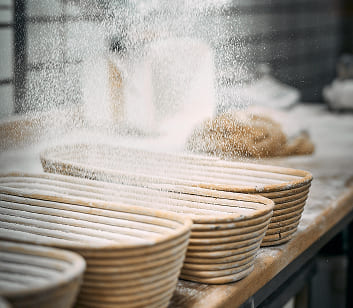 Brotteiglinge von Bäckerei Schrott in Gärkörben, frisch bemehlt und bereit zum Backen.