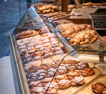 Auslage von Bäckerei Schrott mit frischem Gebäck, Kipferl, Plunder und süßen Mehlspeisen.