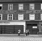 Historische Außenansicht von Bäckerei Schrott mit großem Schriftzug „Schrott“ an der Fassade und Personen vor dem Gebäude.