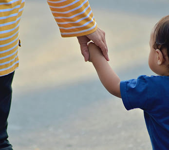 Ein Kind hält die Hand eines Erwachsenen, passend zu Bäckerei Schrott mit familienfreundlichem Frühstück, frischem Brot und Gebäck.