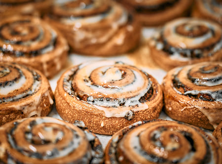 Frische Zimtschnecken von Bäckerei Schrott mit glänzendem Zuckerguss und zarter, goldbrauner Kruste.